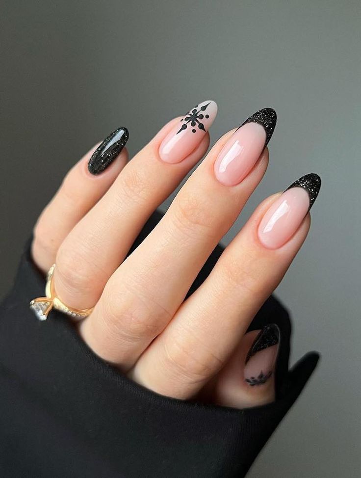 Elegant Nude and Black Nail Design with Glamorous Floral Accents.