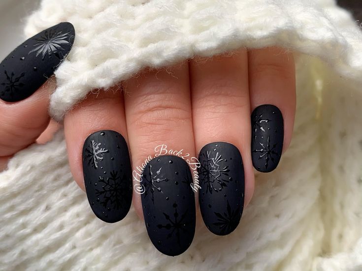 Chic Winter Nail Art: Elegant Matte Black with Intricate Silver Snowflakes.