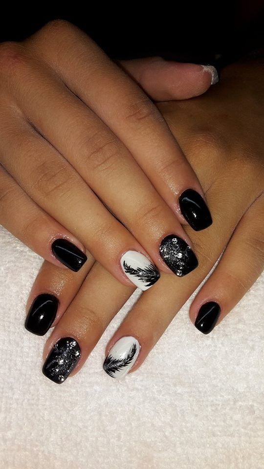 Sophisticated Black and White Nail Design with Intricate Patterns and Embellishments.