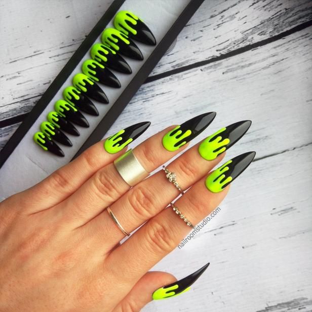 Bold Stiletto Nail Art: Black Base with Neon Green Drips and Statement Rings