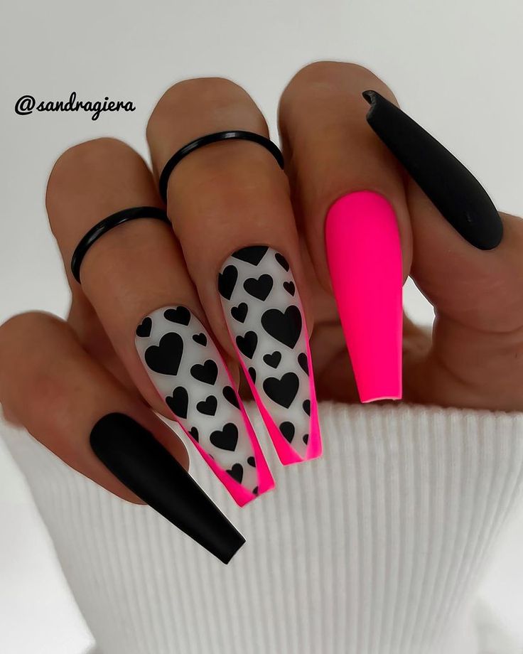 Bold and Playful Nail Design: Matte Black and Bright Pink with Chic Heart Accents.