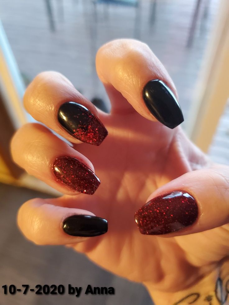 Elegant Almond-Shaped Nail Design: Bold Matte Black and Shimmering Red Glitter Combination.