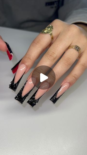 Chic Stiletto Nail Design: Nude Base with Bold Black Accents and Trendy Embellishments.