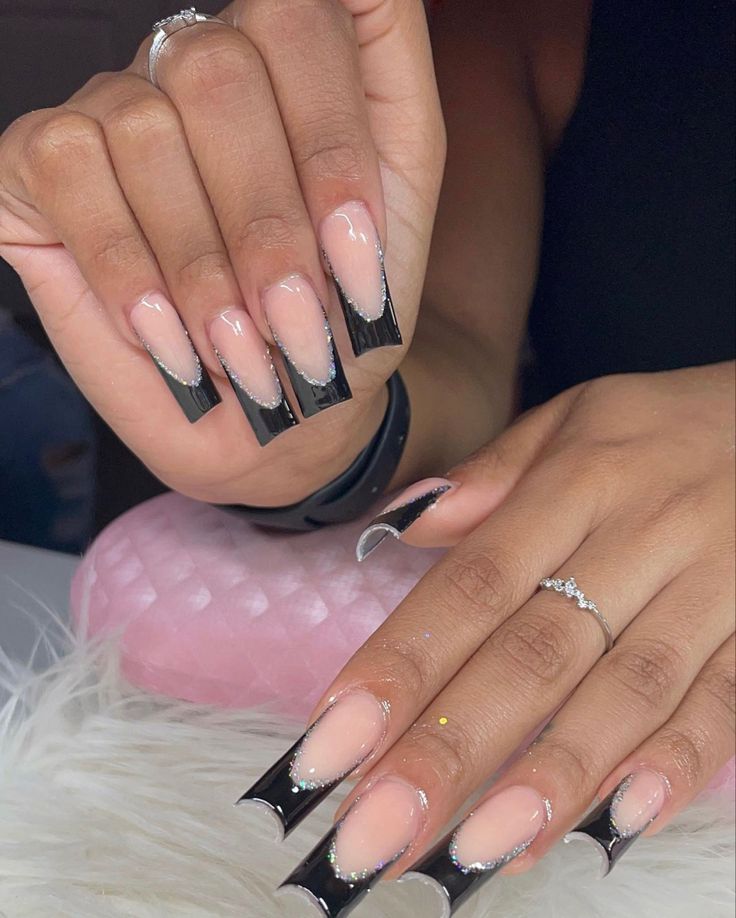 Elegant French Manicure Redefined: Nude Base with Bold Black Tips and Rhinestone Accents.