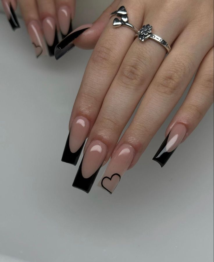 Chic Nude and Black Long Nails with Elegant Tips and Playful Heart Design.