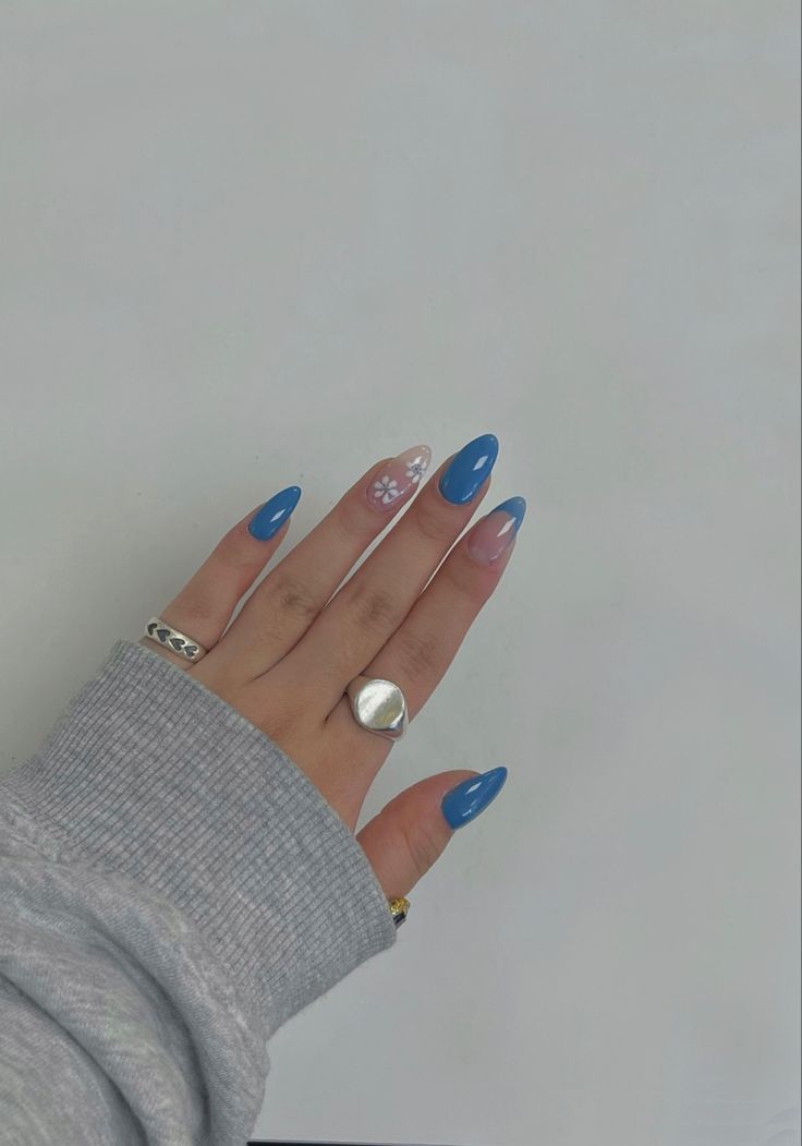 Vibrant Blue Elegant Nail Design with Glossy Finishes and Floral Accent.