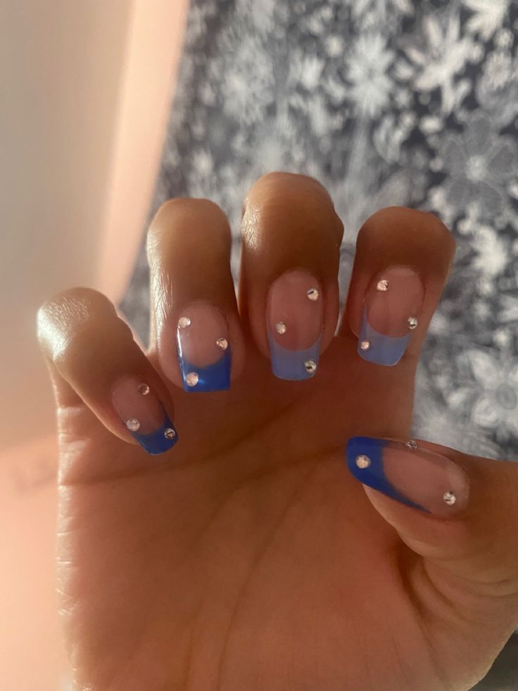 Chic Blue French Tip Nail Design with Nude Base and Rhinestone Accents.