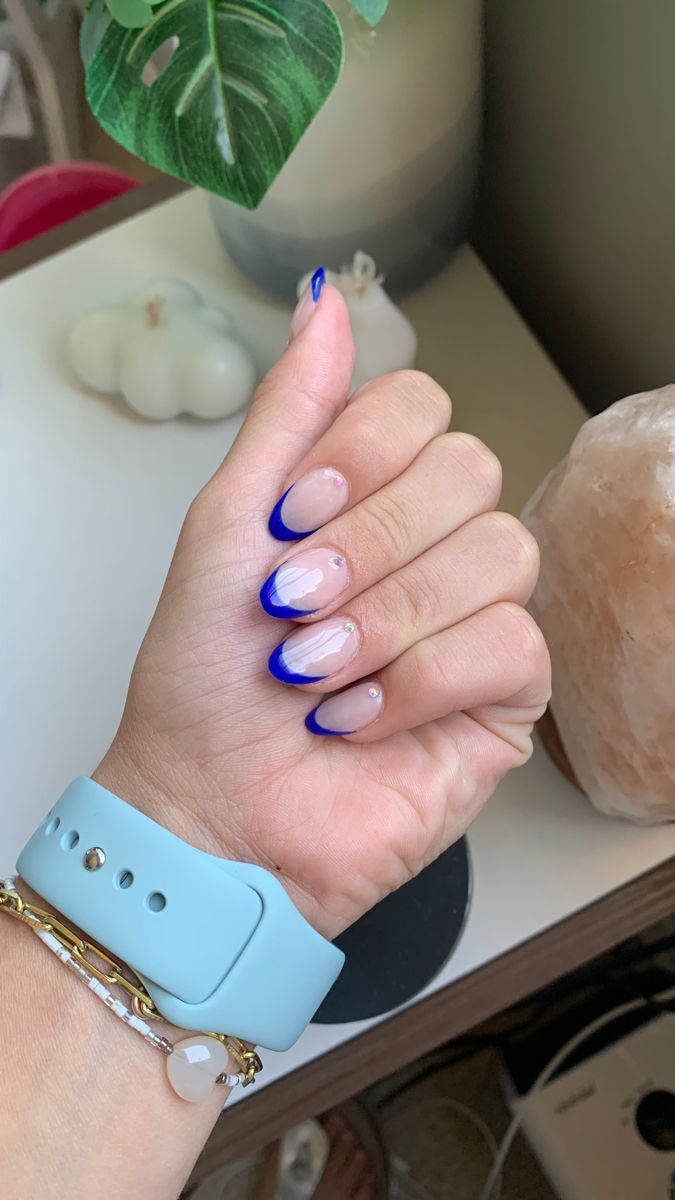 Chic Modern French Manicure: Nude Base with Vibrant Blue Tips and Elegant Embellishments