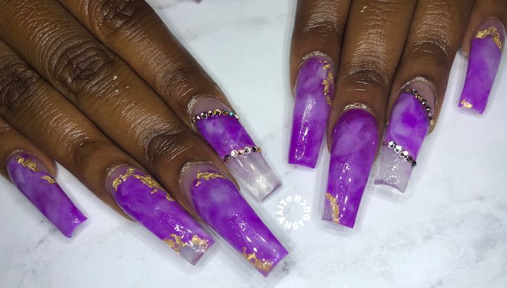 Elegant Purple Nail Design with Marbled Gradient, Gold Accents, and Sparkling Rhinestones.