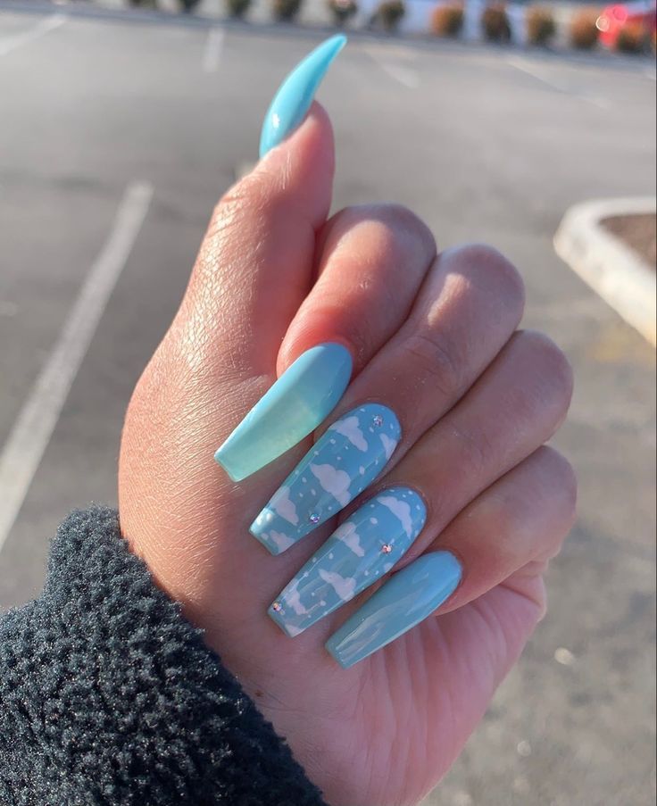 Whimsical Light Blue Nail Design with Matte and Glossy Finishes Featuring Abstract Cloud Patterns.