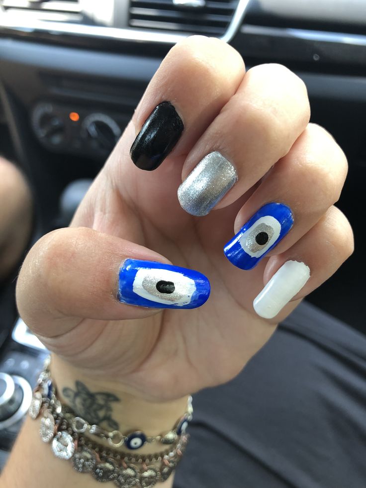 Vibrant and Artistic Nail Design: A Striking Blend of Blue, Black, Silver, and White Patterns.