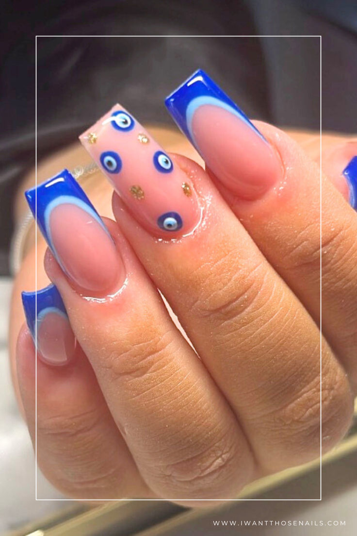 Bold Blue Tipped Nail Art with Intricate Eye Motifs and Glamorous Gold Accents.