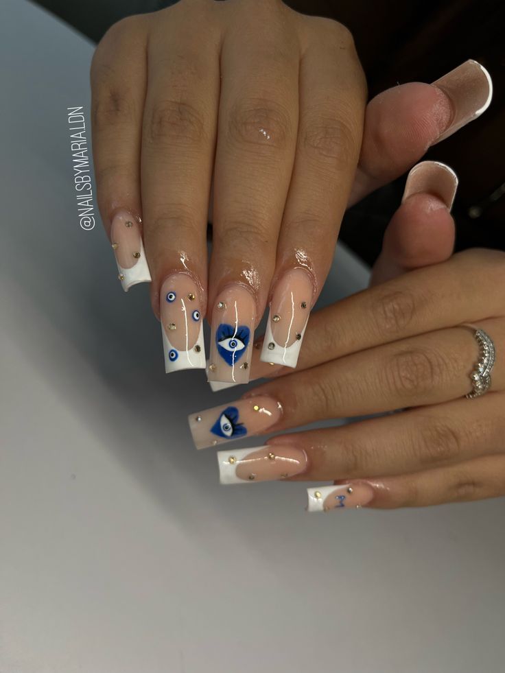 Chic French Tip Nails with Intricate Artwork and Glamorous Blue Accents