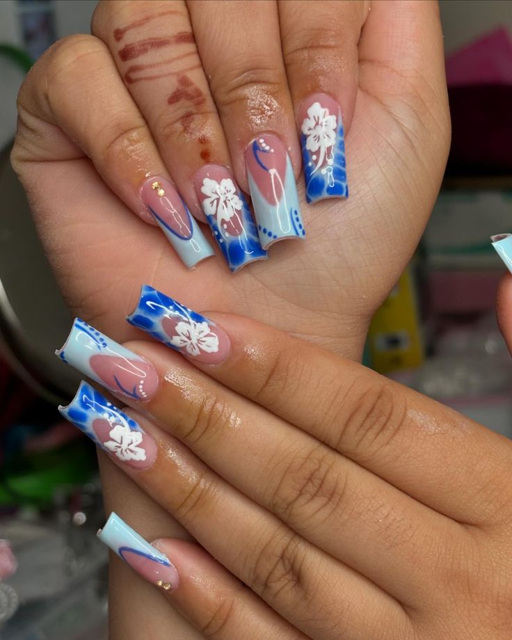 Vibrant Blue and Pink Floral Nail Design with Elegant Gold Accents.