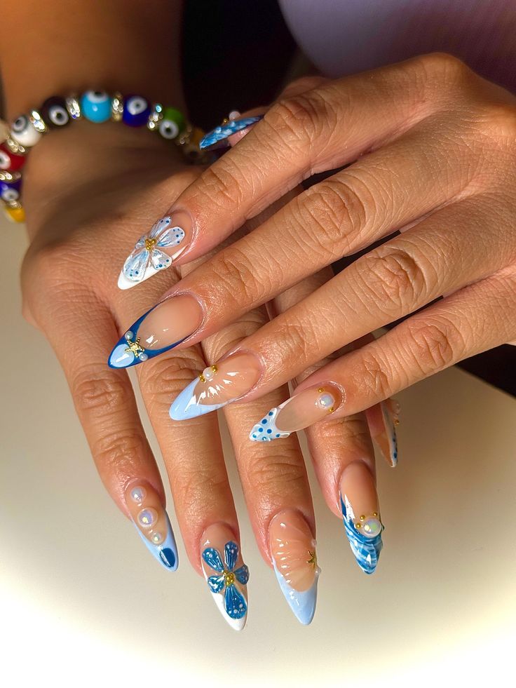 Elegant Three-Dimensional Nail Design with Floral Motifs in Soft Blues.