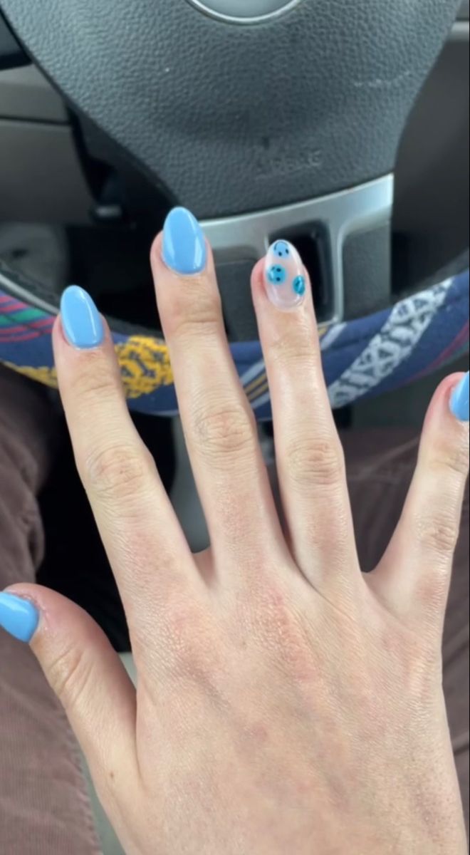 Cheerful Light Blue Nail Design with Whimsical Polka Dot Accent.