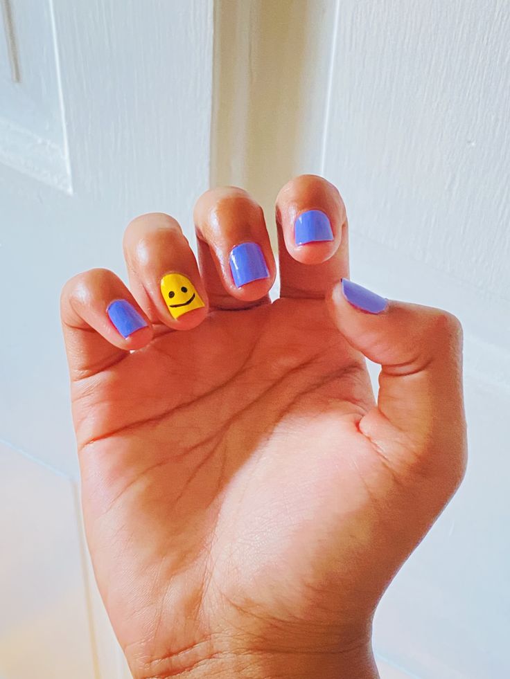 Whimsical Playful Blue Nail Design with Cheerful Face Accent