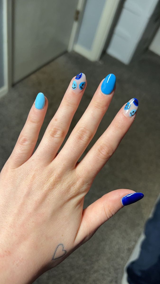 Playful Vibrant Blue Nail Design: Artful Fusion of Solid and Patterned Styles.