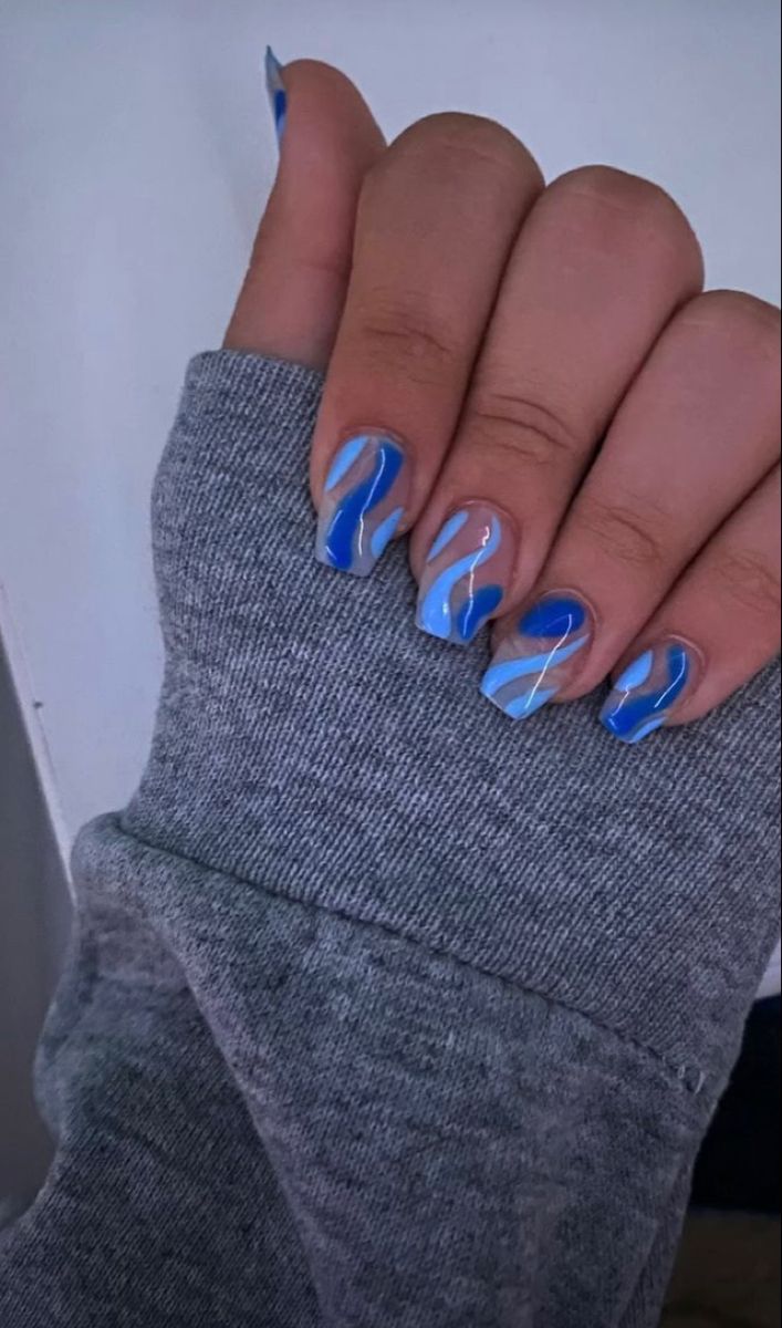 Ocean-Inspired Glossy Nail Design with Blue Waves and White Accents