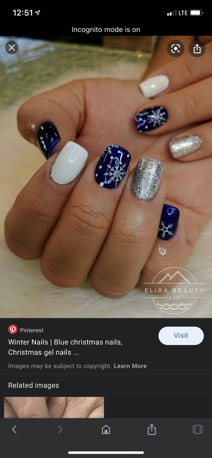 Elegant Festive Winter Nail Design with Navy Blue, White, and Silver Snowflake Motifs.