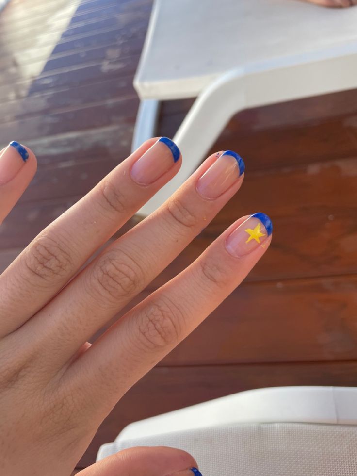 Vibrant Blue Tips and Whimsical Yellow Star Create Playful Nail Design.