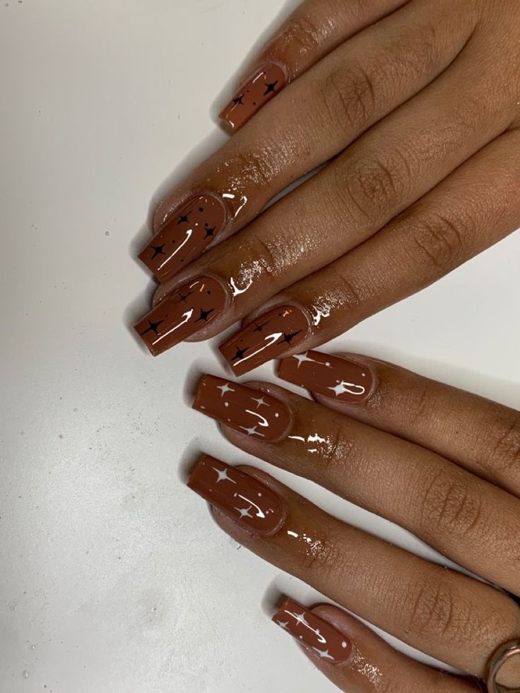 Trendy Glossy Brown Nail Design with Intricate Black Arrow Accents