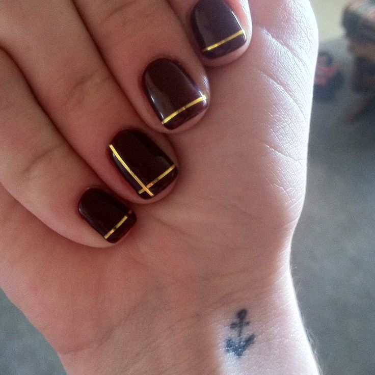 Chic Dark Burgundy Nails with Glamorous Gold Striping for Elegant Occasions