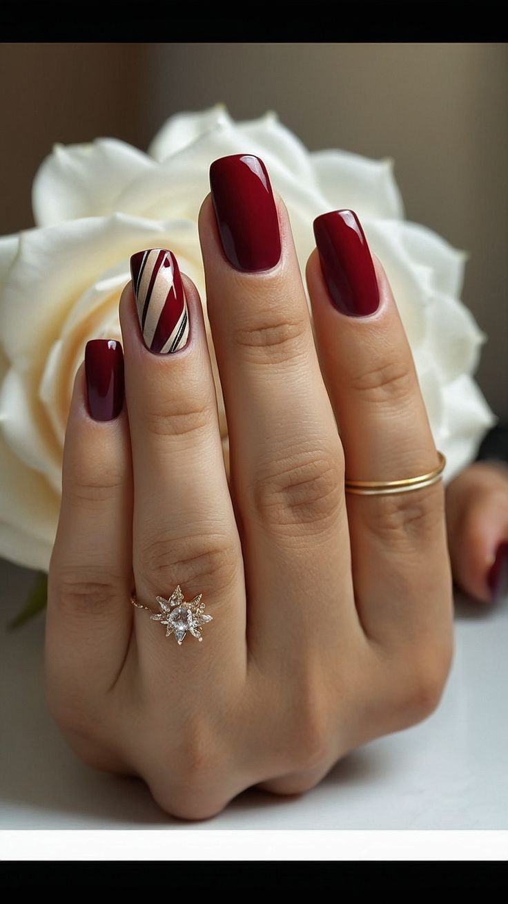 Luxurious Deep Burgundy Nail Design with Chic Striped Accent and Elegant Ring.