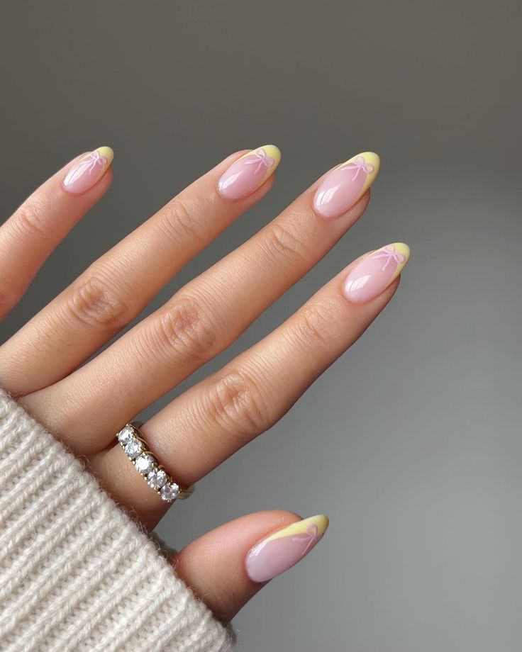 Sophisticated Elegant Nail Design: Soft Pink Base with Vibrant Yellow Tips and Floral Accents.