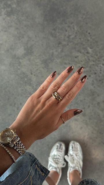 Sophisticated Almond-Shaped Brown Glossy Nail Design Complemented by Elegant Accessories.