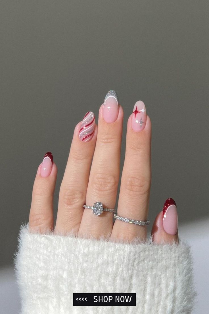 Chic Festive Nail Design: Pink and Red Hues with Shimmering Silver Tips and Whimsical Accents.