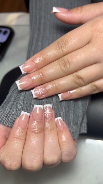 Chic French Tip Nail Design with Playful Snowflake Accents for Seasonal Style.