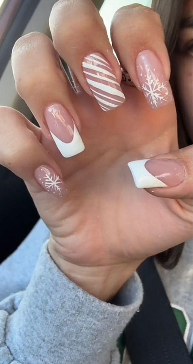 Elegant Winter-Inspired Nail Design: Festive Shades of Soft Pink and Crisp White with Snowflakes and Stripes.