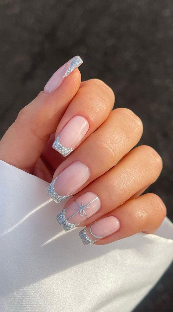 Charming Elegant Nail Design: Soft Pink Polish with Silver Tips and Bow Detail.