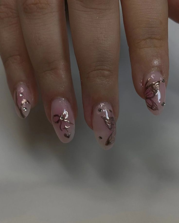 Elegant Soft Pink Nail Design with Gold Foil and Floral Accents.