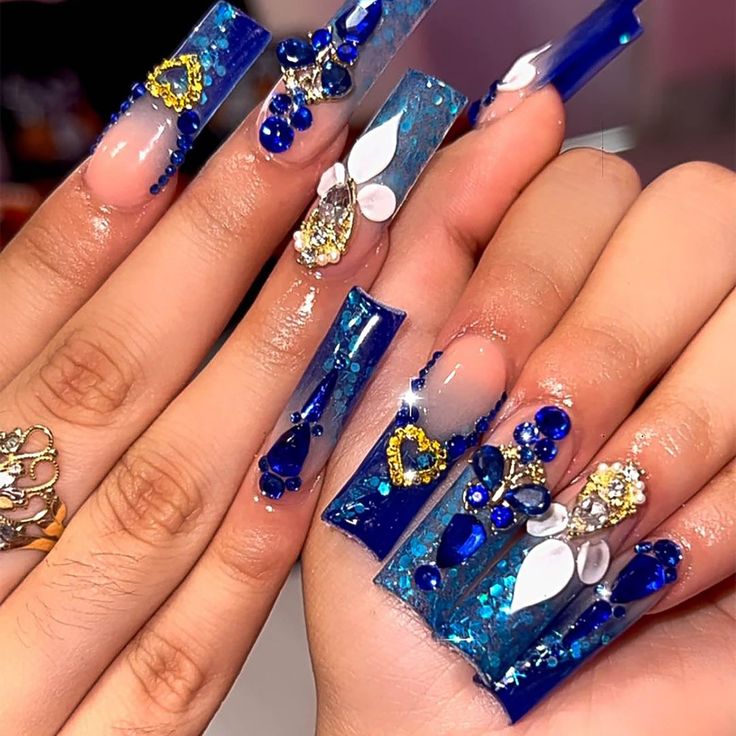 Striking Bold Blue Nails with Intricate Designs and Glamorous Embellishments