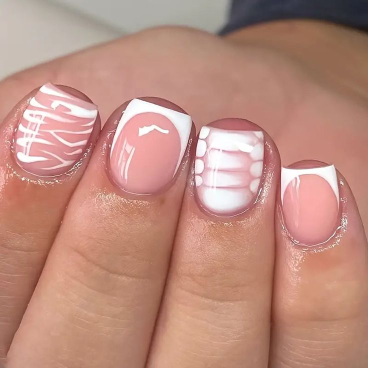 Elegant Nail Design with Subtle Pink and Bold White Elements Featuring Intricate Patterns.