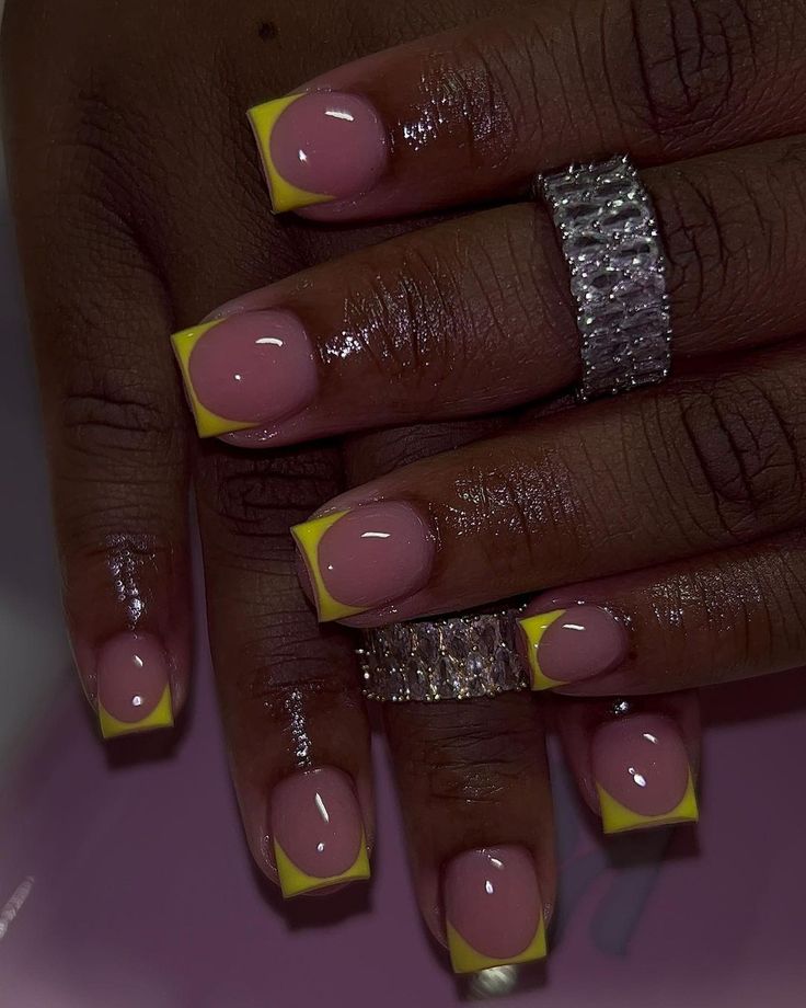 Chic Nail Design: Glossy Pink Base with Vibrant Yellow French Tips for a Modern Touch.