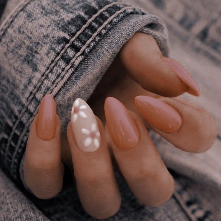 Chic Nude Almond-Shaped Nails with Whimsical Floral Accent Design.