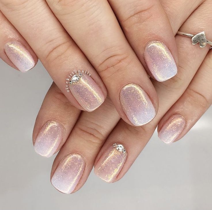 Ethereal Glistening Ombre Nails with Pink and Lavender Hues, Enhanced by Shimmer and Rhinestone Accents.