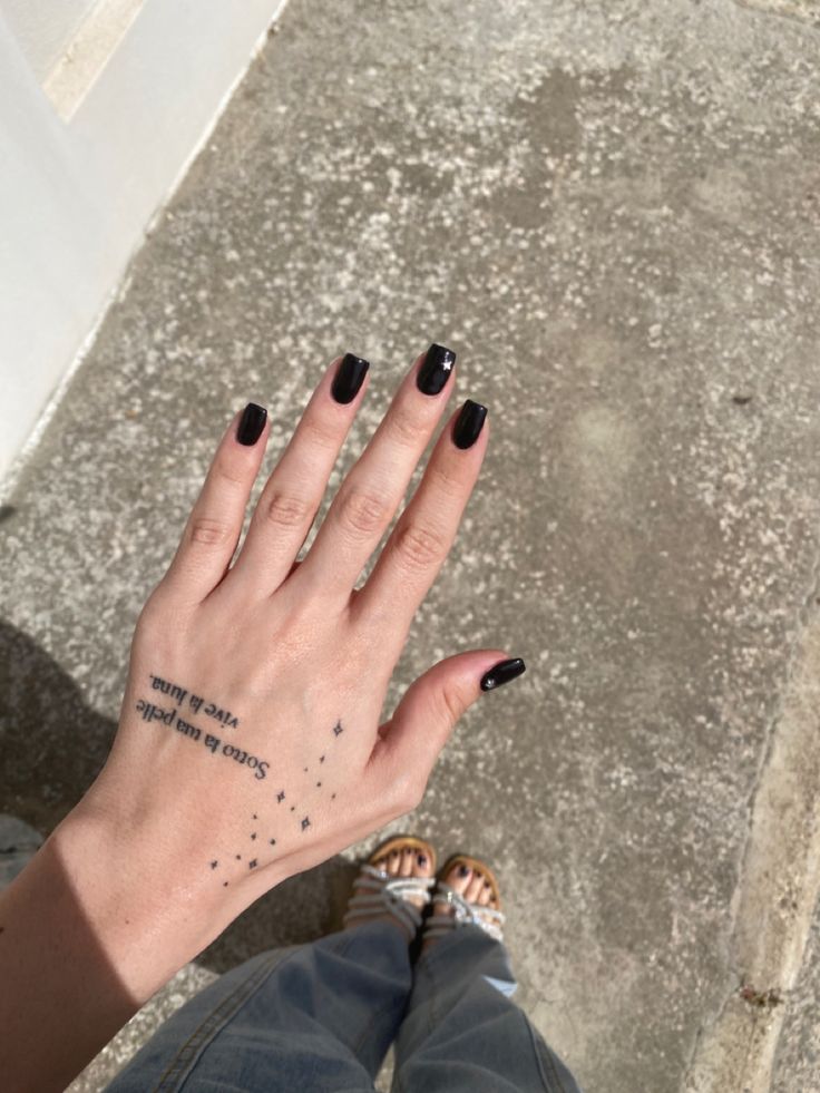 Chic Black Glossy Nails with Celestial Accents: A Versatile Trend for Any Occasion.