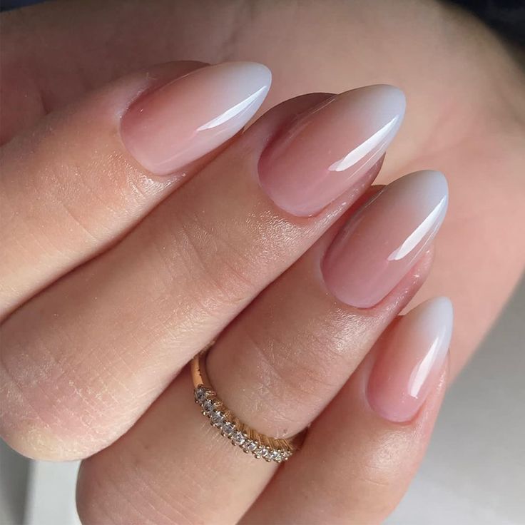 Elegant Ombre Nail Design: Soft Nude to White Gradient with Almond Shape and Glossy Finish.