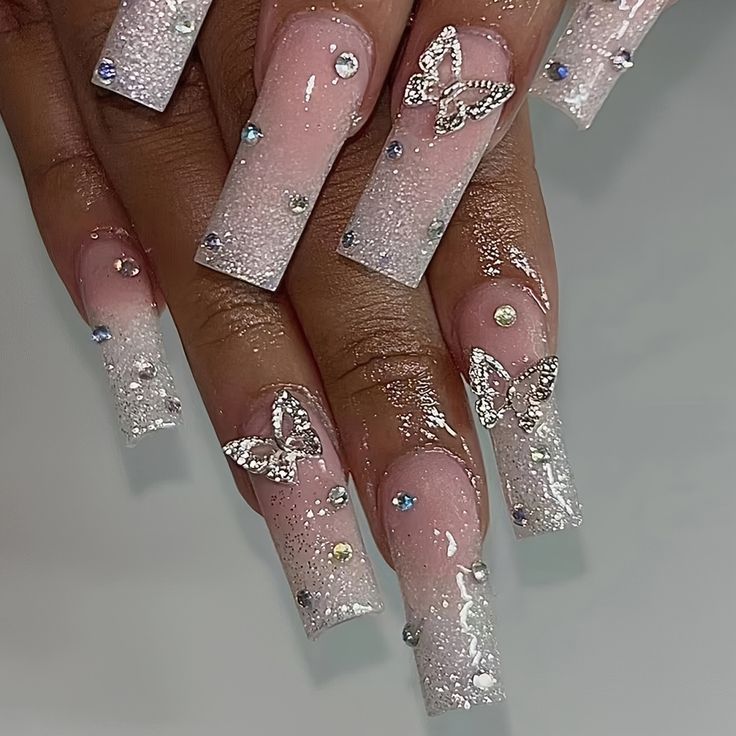 Chic Ombre Pink and White Butterfly Nail Design with Rhinestones and Silver Accents.