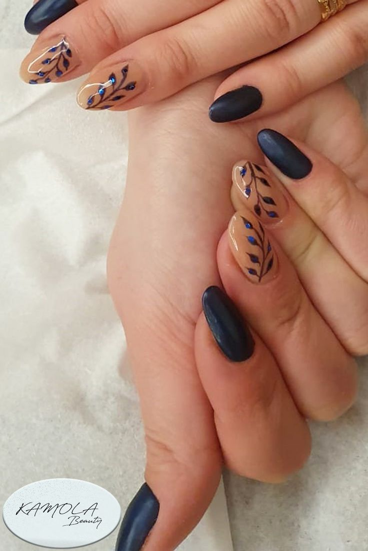 Chic Matte Dark Blue and Glossy Nude Nail Design with Intricate Leaf Patterns.