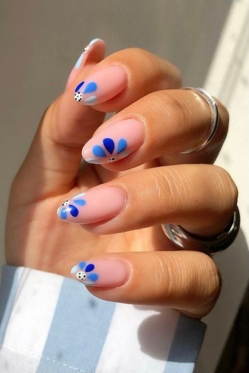 Playful Floral Nail Design with Blue Petals and Soft Pink Base.