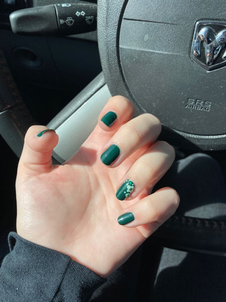 Chic and Sophisticated Emerald Green Nail Design with Playful Dot Accent.