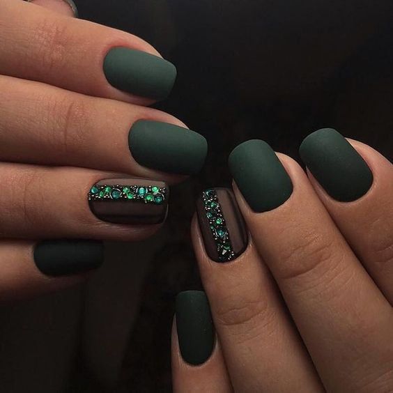 Sophisticated Matte Green Nails Adorned with Gemstones for a Chic Aesthetic.