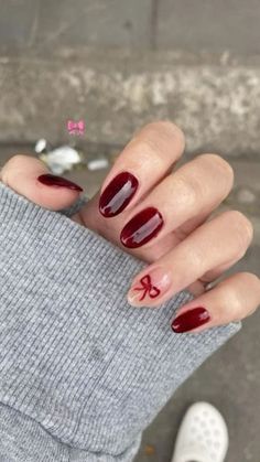 Sophisticated Deep Burgundy Nail Design with Playful Bow Accent.