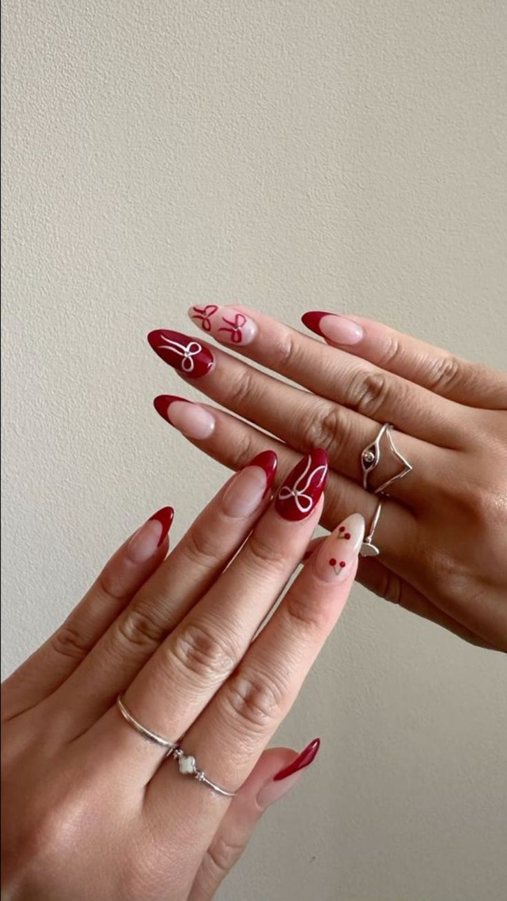 Whimsical Elegant Nail Design Featuring Deep Red and Soft Nude Shades with Intricate Details.