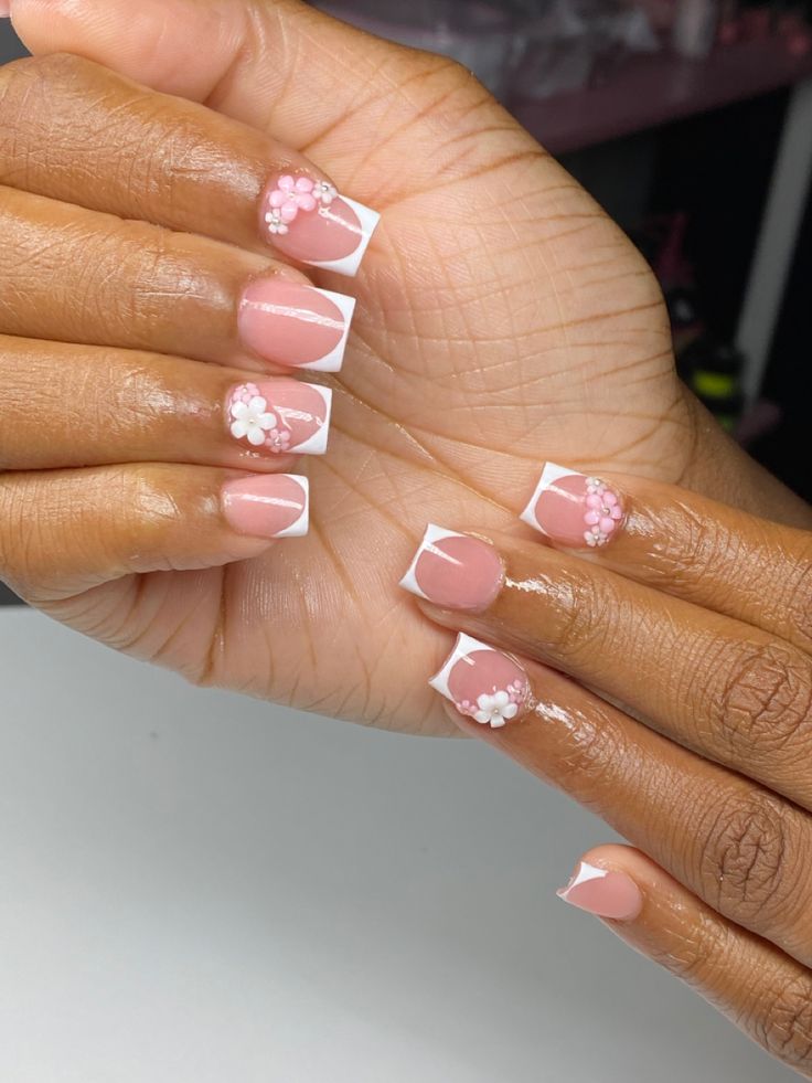 Chic Soft Pink Nail Design with French Tips and Floral Accents.